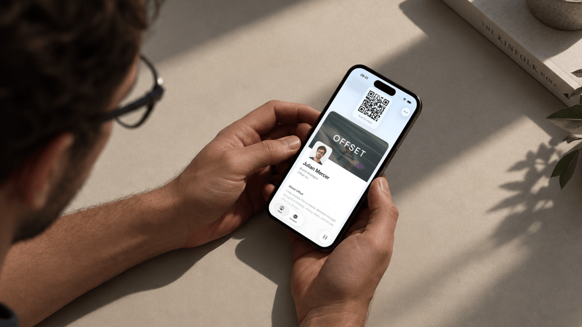 A person holding a phone displaying a Tapify digital business card and QR code