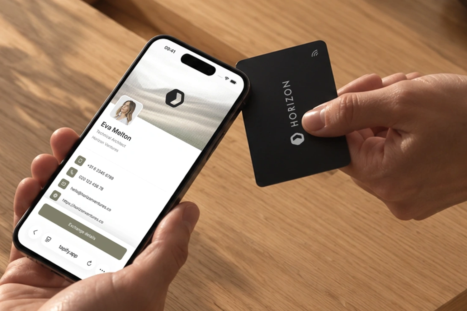 Een NFC-visitekaartje bij de bovenkant van een iPhone met het digitale visitekaartje geopend op het scherm